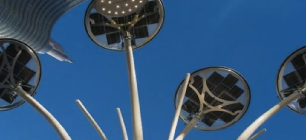 Upward view of multiple solar panel streetlights against a clear blue sky.