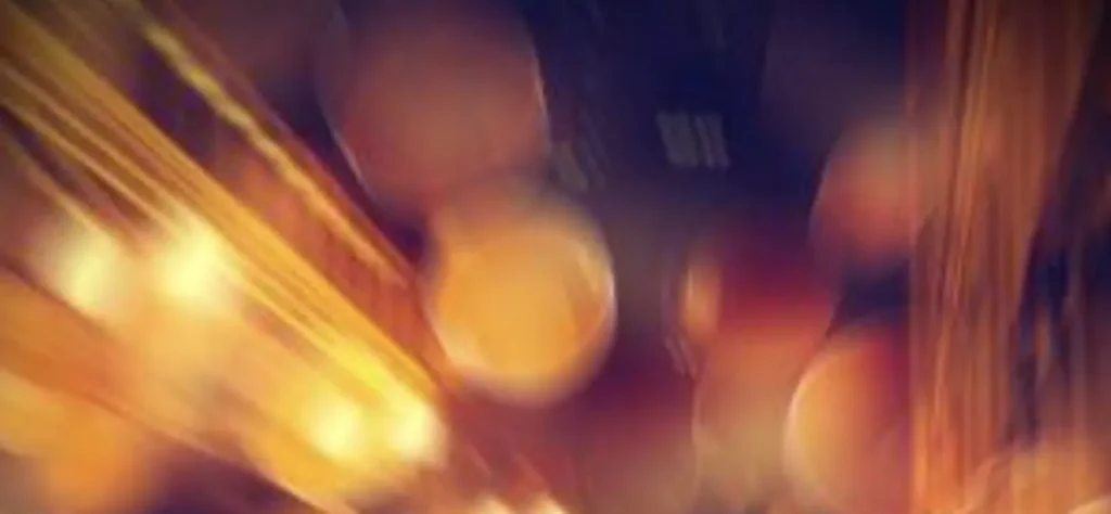 Abstract blurred image featuring warm orange and yellow lights with circular bokeh effects.