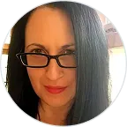 Portrait of a woman with long dark hair, black glasses, and red lipstick.